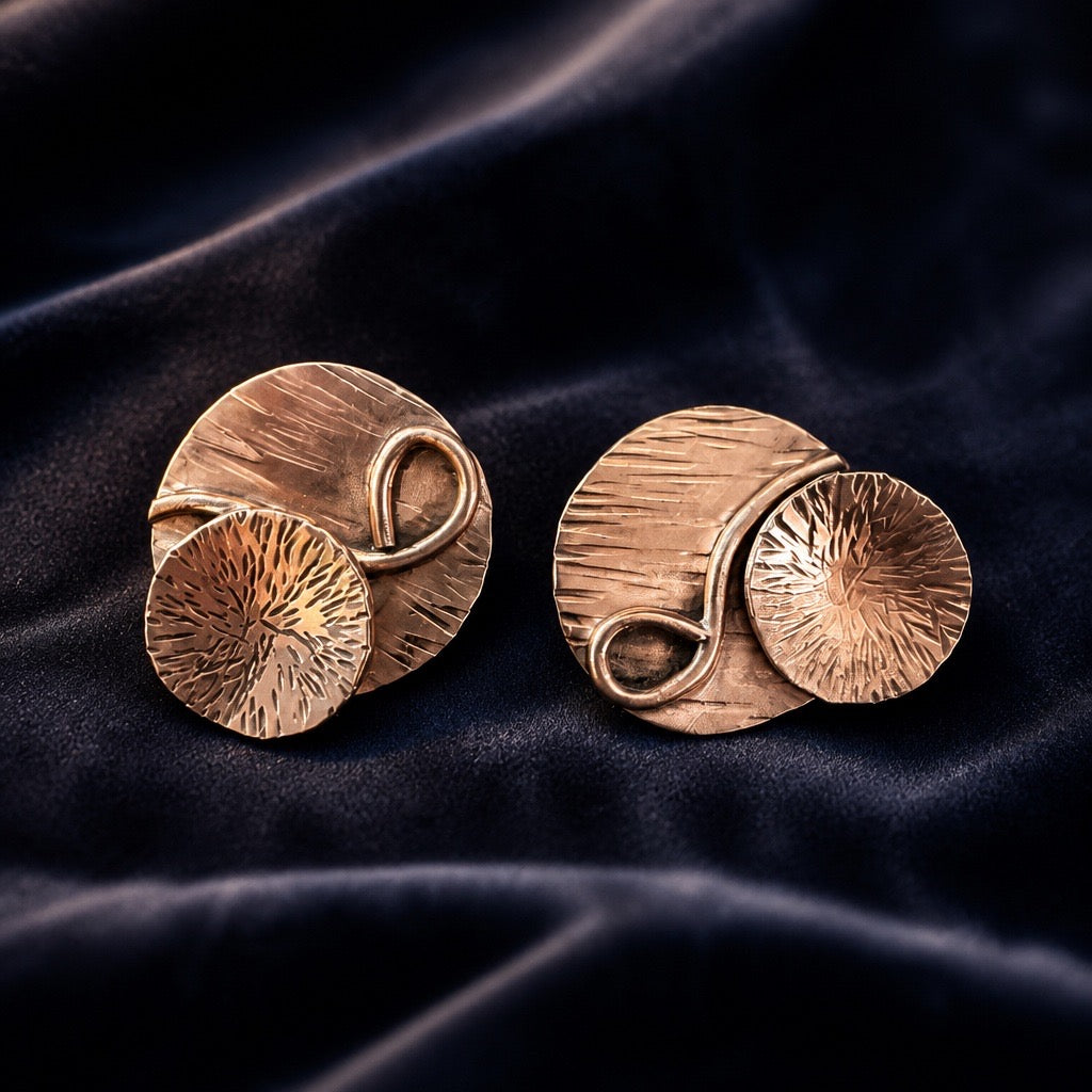 Close-up of handcrafted, asymmetrical, layered copper earrings showing antiqued finish and organ texture - artisan jewelry by Ginny Taylor Designs