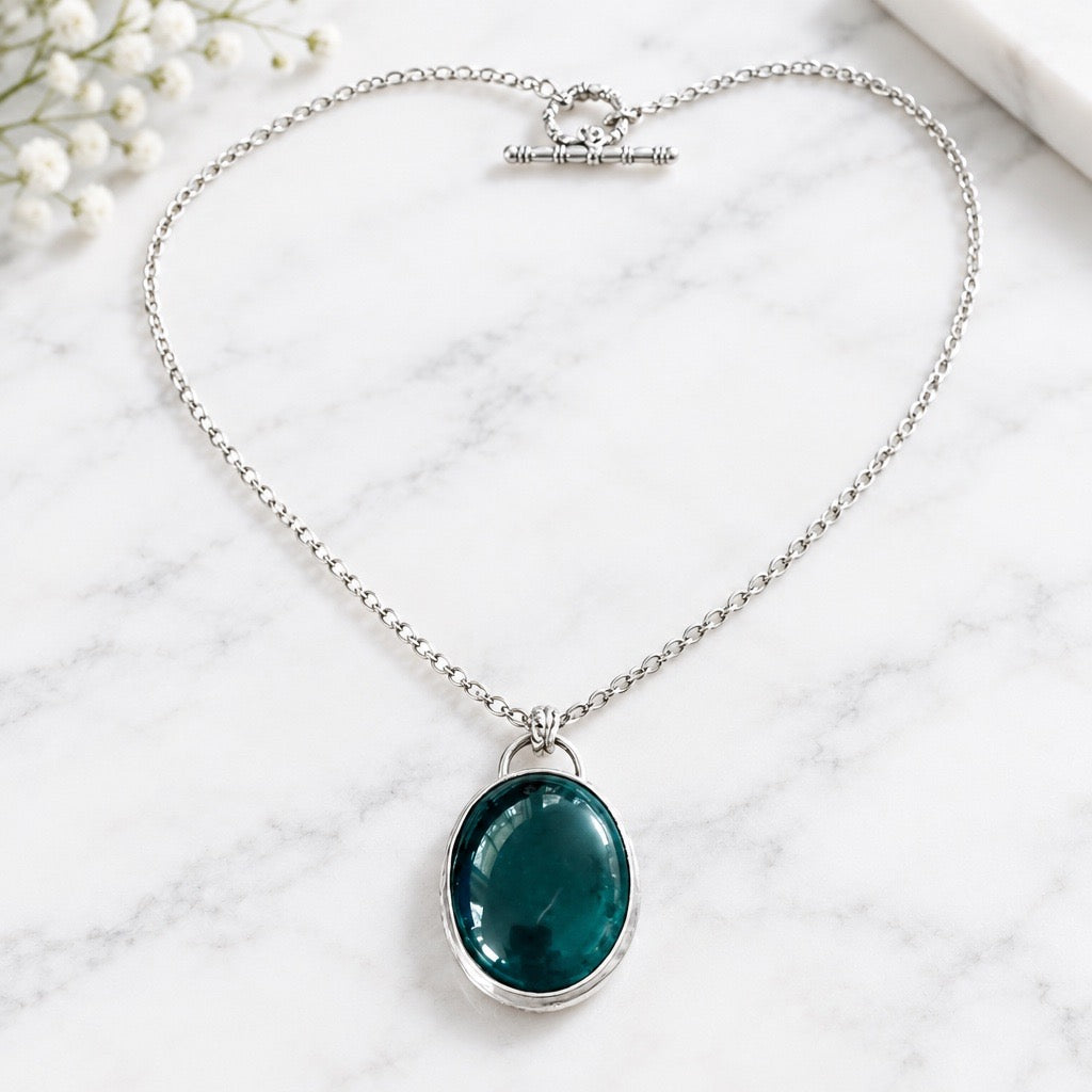 Handmade London blue topaz oval pendant necklace with silver bezel setting and decorative heart toggle clasp - handmade by Ginny Taylor Designs in her studio in Roanoke, VA